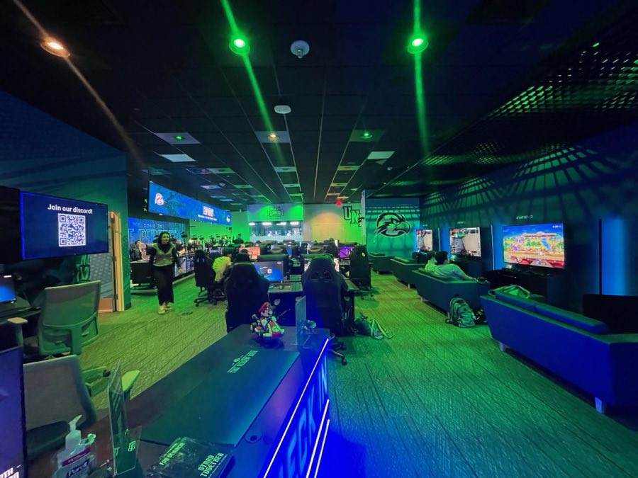 Rows of gaming stations under green arena lighting